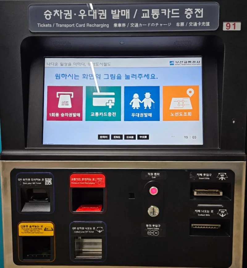 釜山の地下鉄駅の券売機。画面に「1회용 승차권발매」「교통카드충전」などのボタンがあり、下にQR乗車券の読み取り口と紙幣の投入口がある