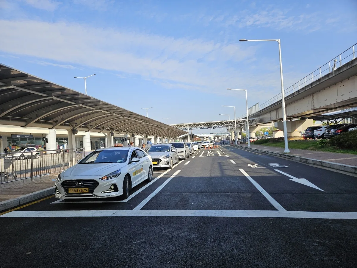 金海空港のタクシー乗り場。屋根の下に白いタクシーが並んでいる