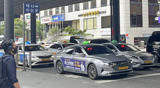 乗り場に並ぶ釜山の一般タクシー。白やシルバーの車の屋根にタクシーの表示灯がある