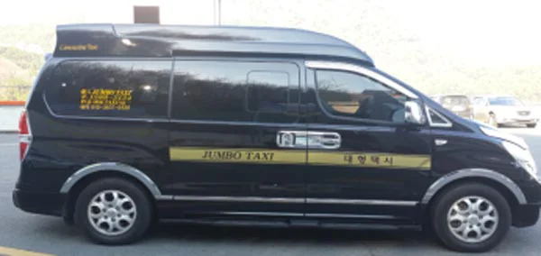 黒いワゴン車の横に「JUMBO TAXI 대형택시」と書いてある
