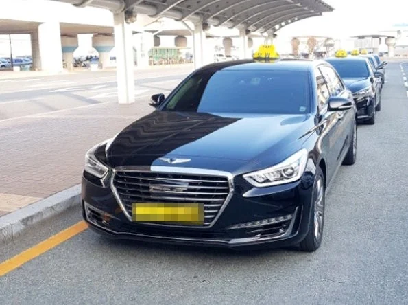 黒い車体の模範タクシー。屋根に黄色の表示灯がある