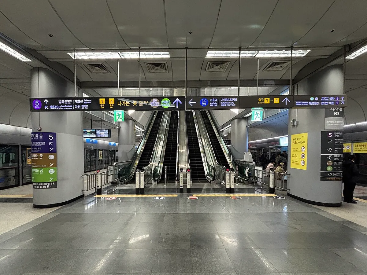 金浦空港駅の地下ホーム。エスカレーターの上にソウル駅・デジタルメディアシティ方面の案内が出ている