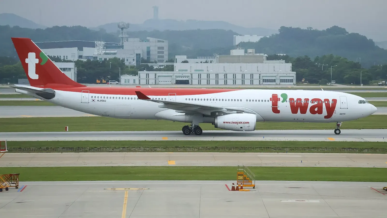 仁川空港の滑走路を走るティーウェイ航空のエアバスA330-300。白い機体に赤い尾翼