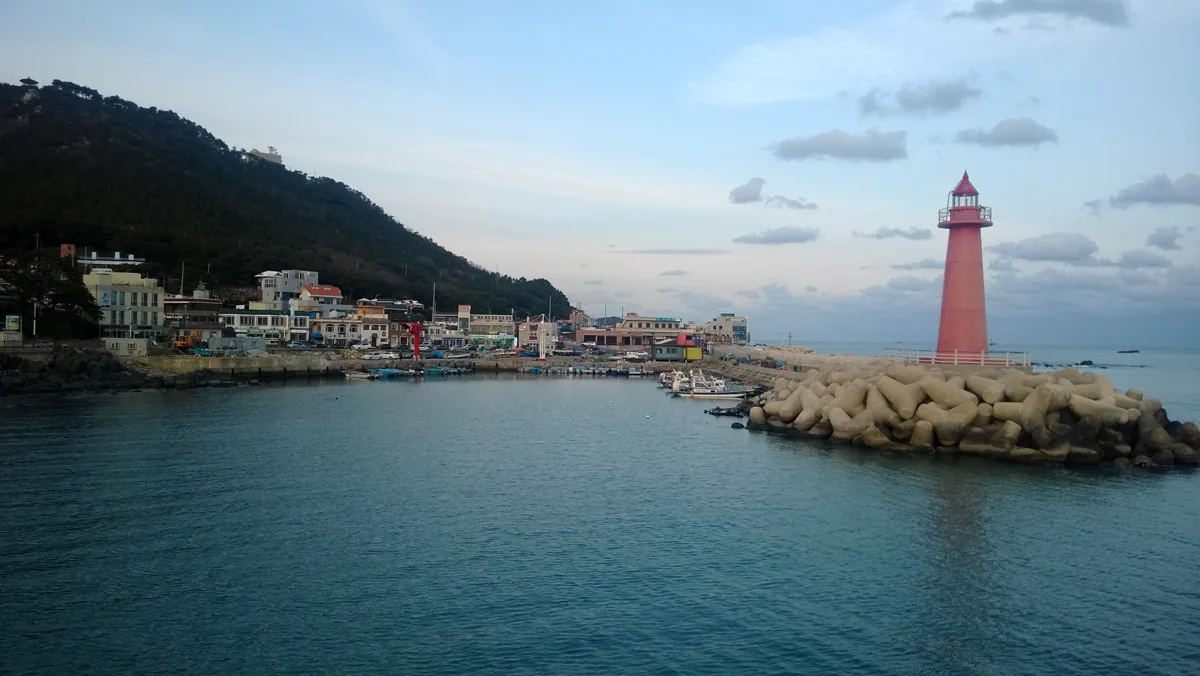 赤い灯台が立つ青沙浦の海辺