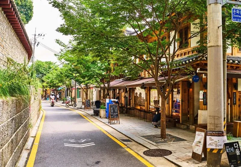 韓屋の店が並ぶ石垣沿いの道
