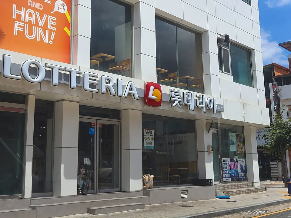 白いタイル張りの建物に、LOTTERIAとハングルの롯데리아の看板が並ぶロッテリアの店