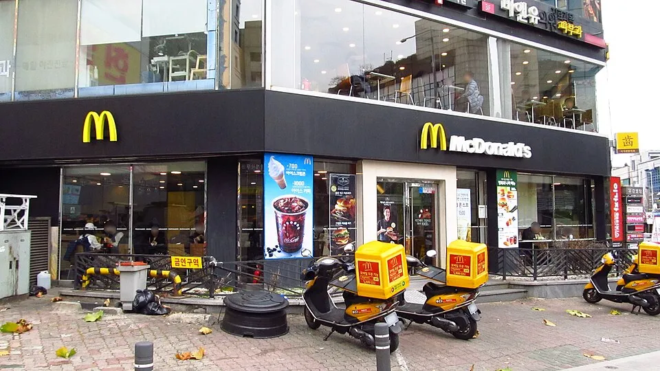 マクドナルドの店の前に、黄色い配達用のバイクが並んでいる
