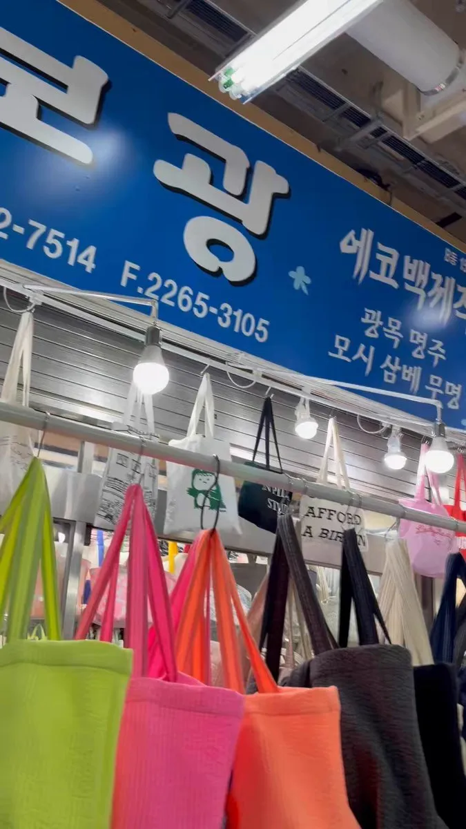 ボクァンの青い看板と、店先に掛かった色とりどりのバッグ