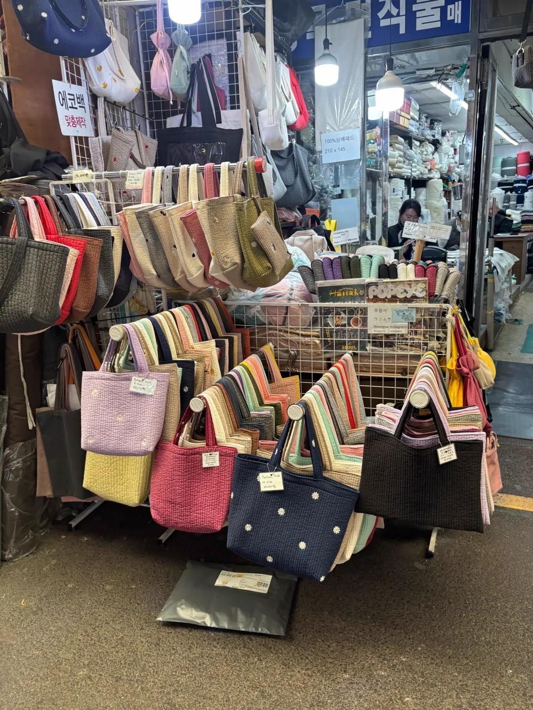 広蔵市場の店先に並んだ無地と刺繍のヌビバッグ