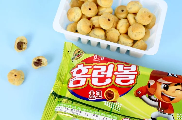 黄緑の袋の「홈런볼 초코」と、トレーに入った丸いお菓子