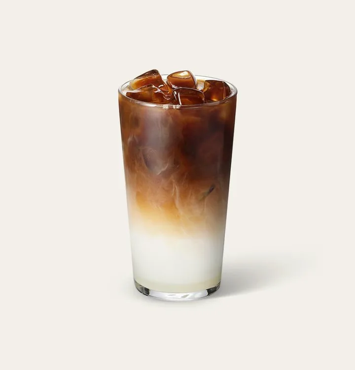 氷の入ったグラスに、コーヒーと白いミルクが層になったドリンク