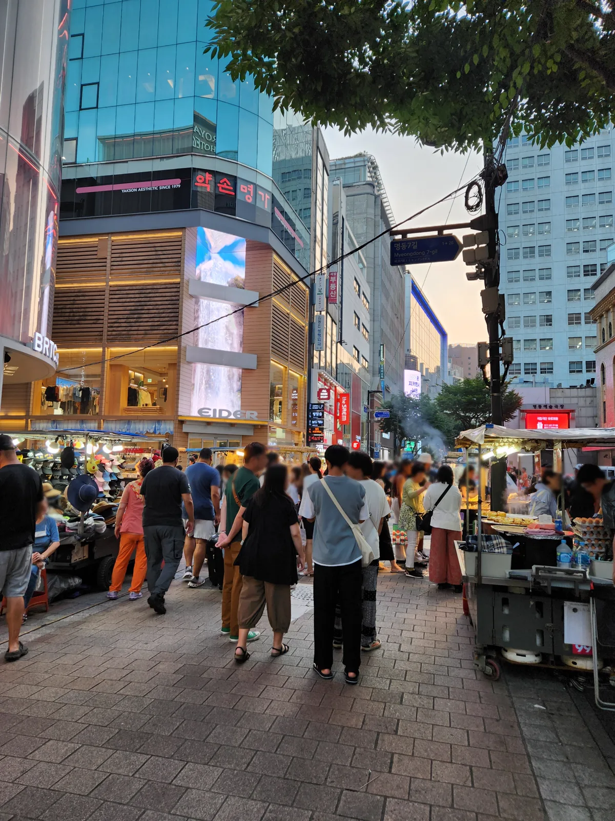 夕方の明洞7ギルに並ぶ店舗と屋台