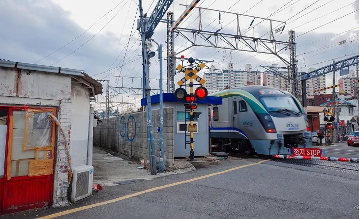 遮断機の外から見た、踏切を通る電車