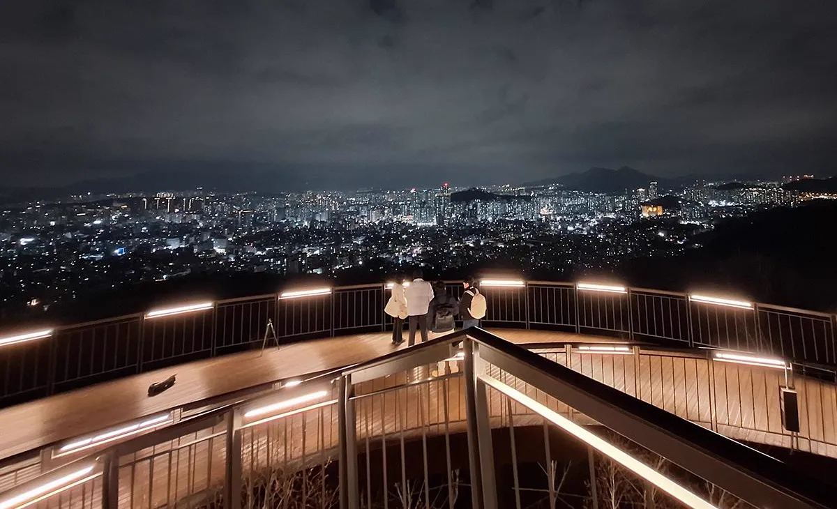 光るデッキの曲線を手前に、奥に夜の街