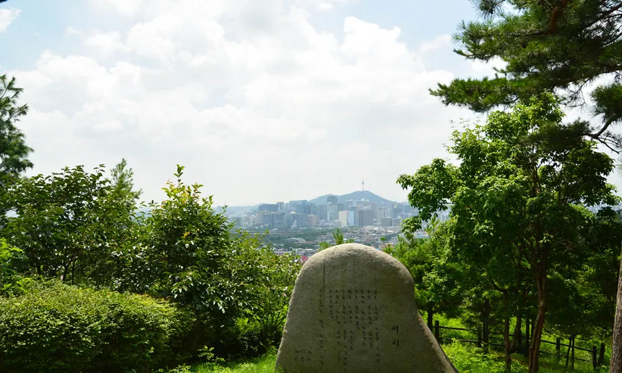 「序詩」の石碑を手前に、奥に街と南山タワー