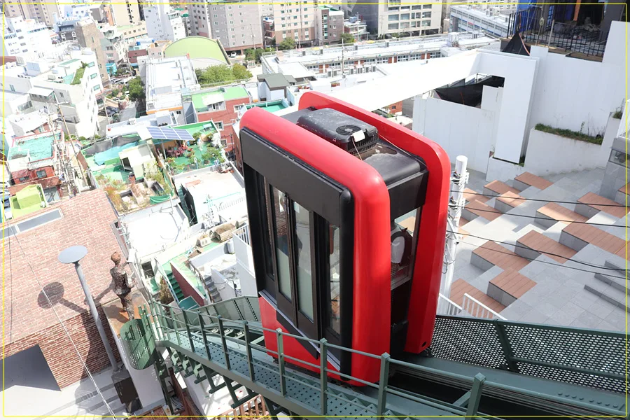 168階段 — 赤い車両と斜面の街並み