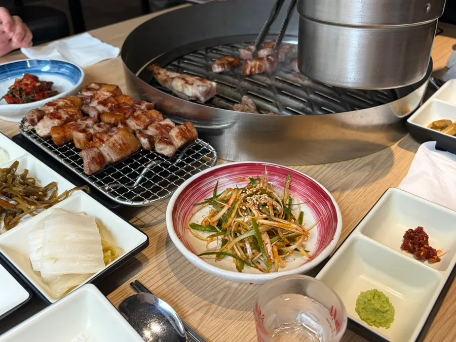 1PIG 益善店 — 焼いた豚肉とおかずが並ぶ食卓