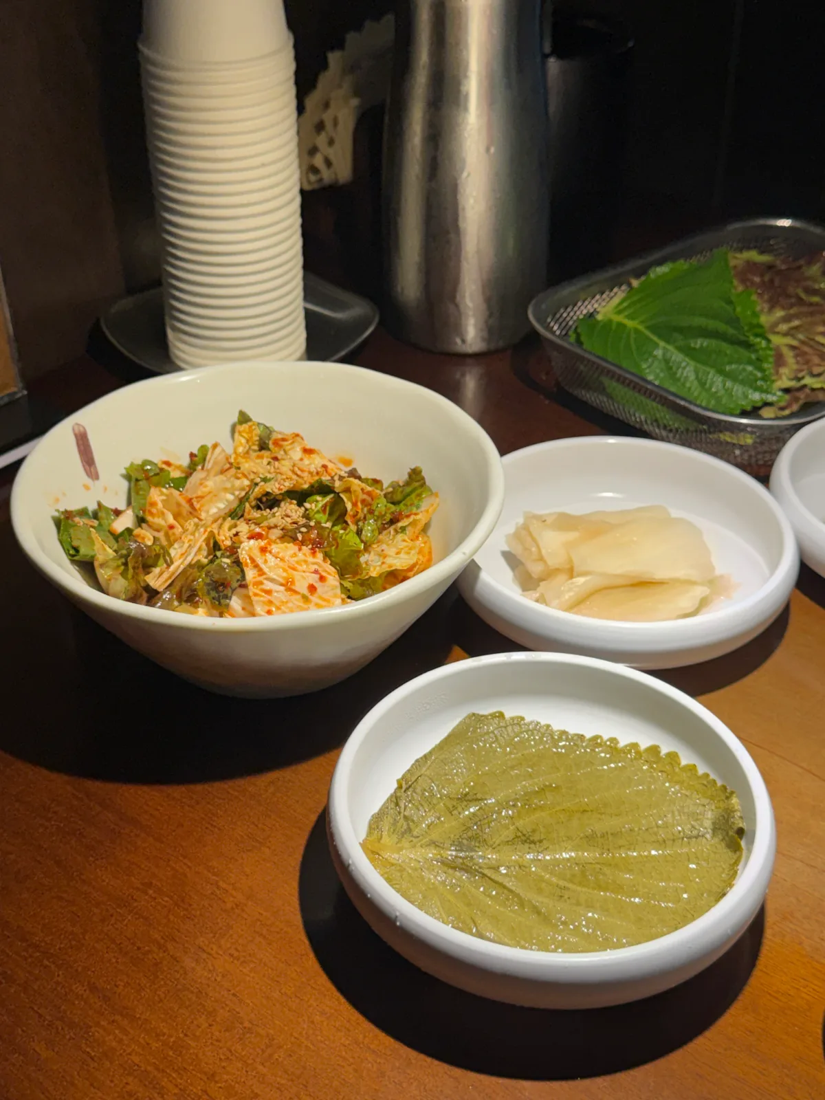 白菜の浅漬けキムチやエゴマの葉の漬物が並ぶ小皿