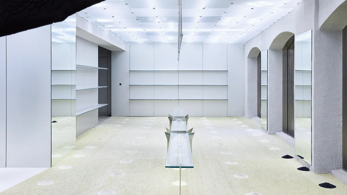 ADERERROR 聖水店 — 白い棚と透明な展示台