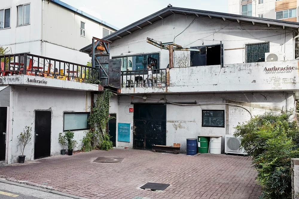 Anthracite Coffee 合井店 — 白壁と鉄柵のカフェ建物