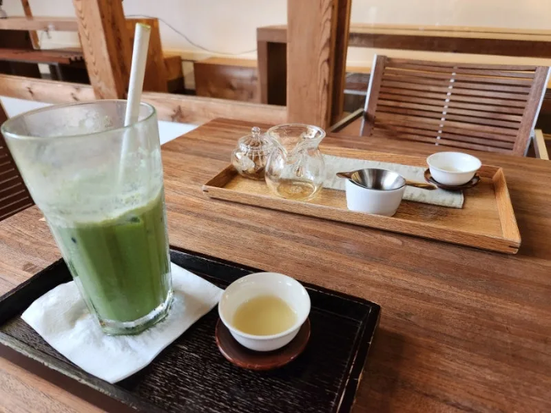 アルムダウン茶博物館 — 木の卓上に置かれた緑色の冷茶