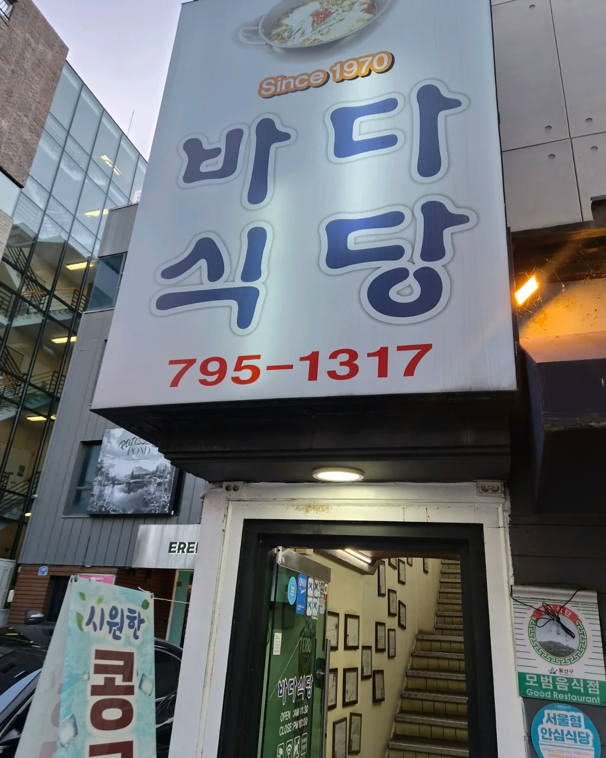 パダ食堂 — 店名看板と階段入口