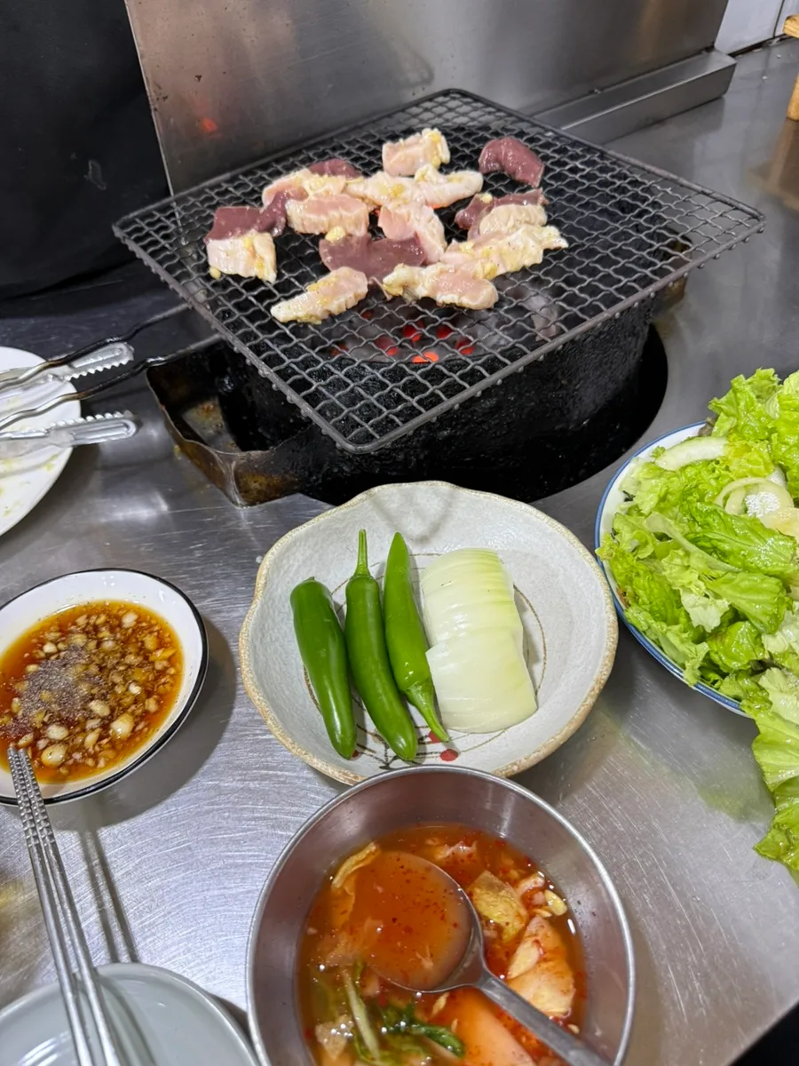 ペックァヤンコプチャン — 焼き網を囲む肉と野菜、たれ