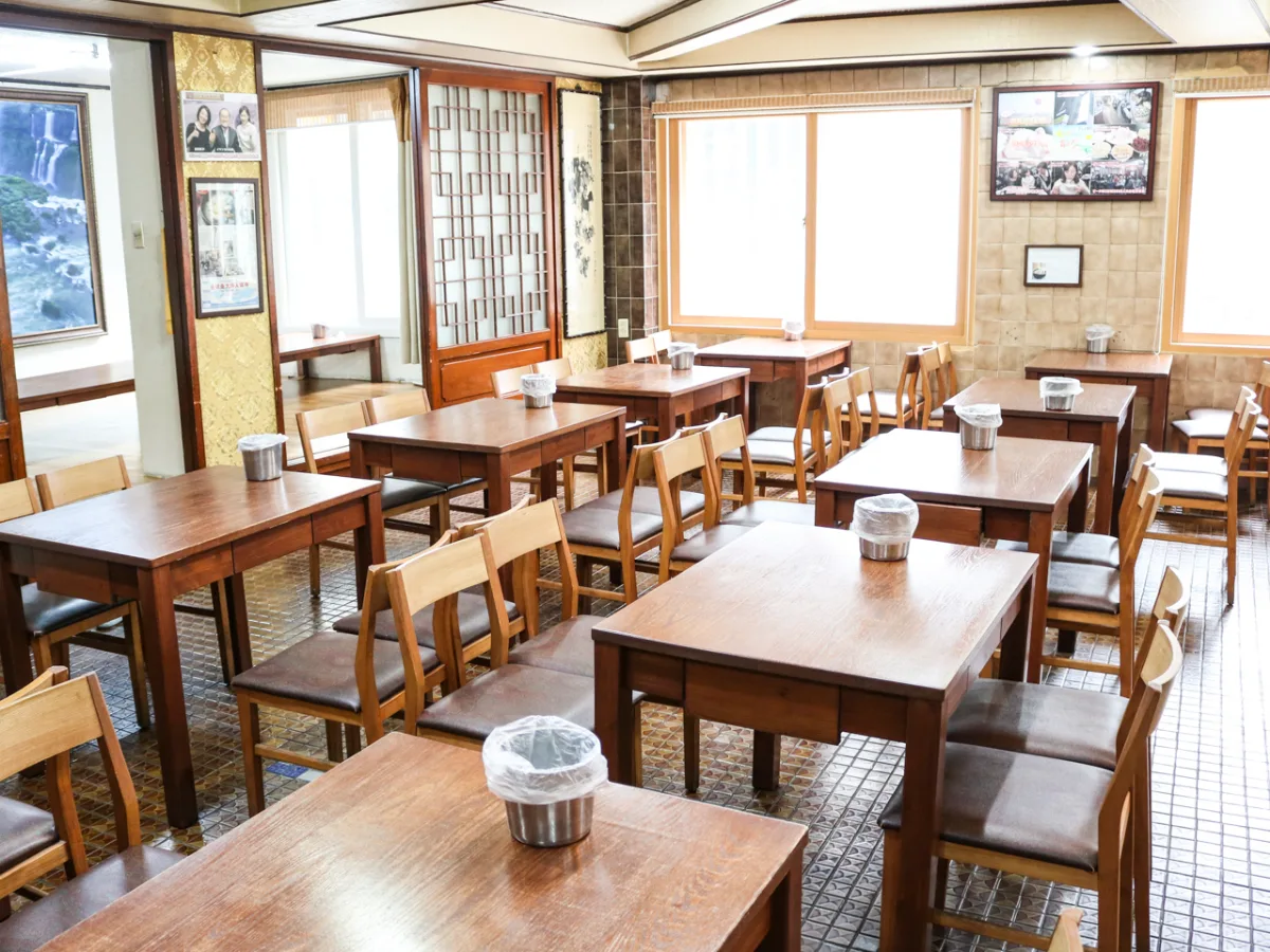 木の卓が並ぶ窓辺の食堂