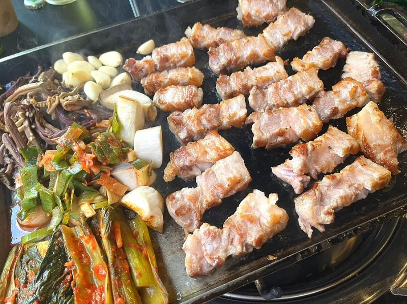鉄板で焼く豚肉とキムチ