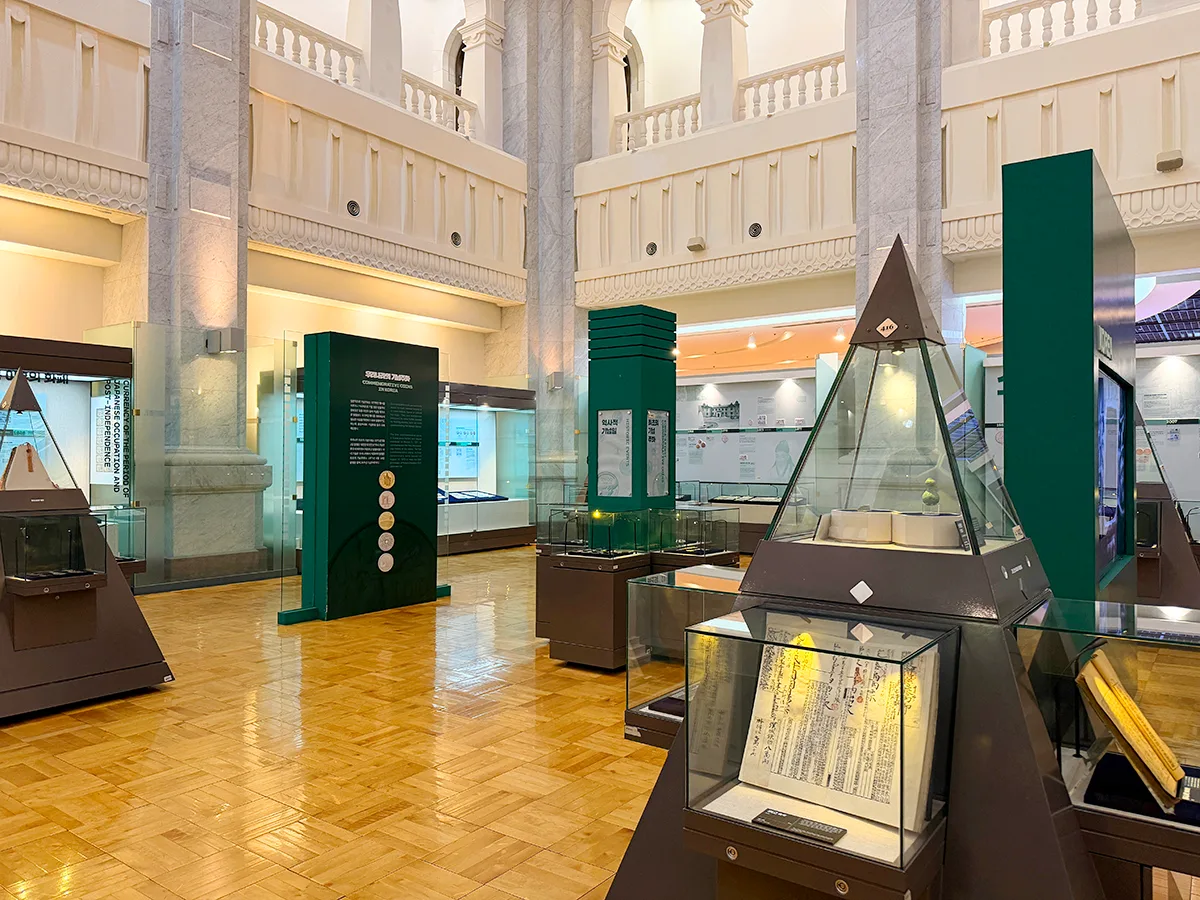 韓国銀行貨幣博物館 — 大理石柱と三角形の展示ケース