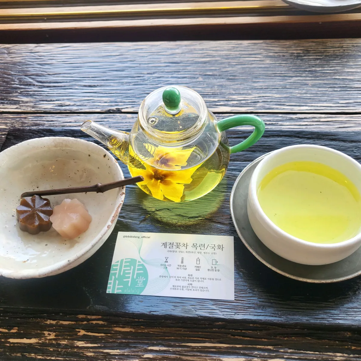 黄色い花が浮かぶ急須と茶菓子二種