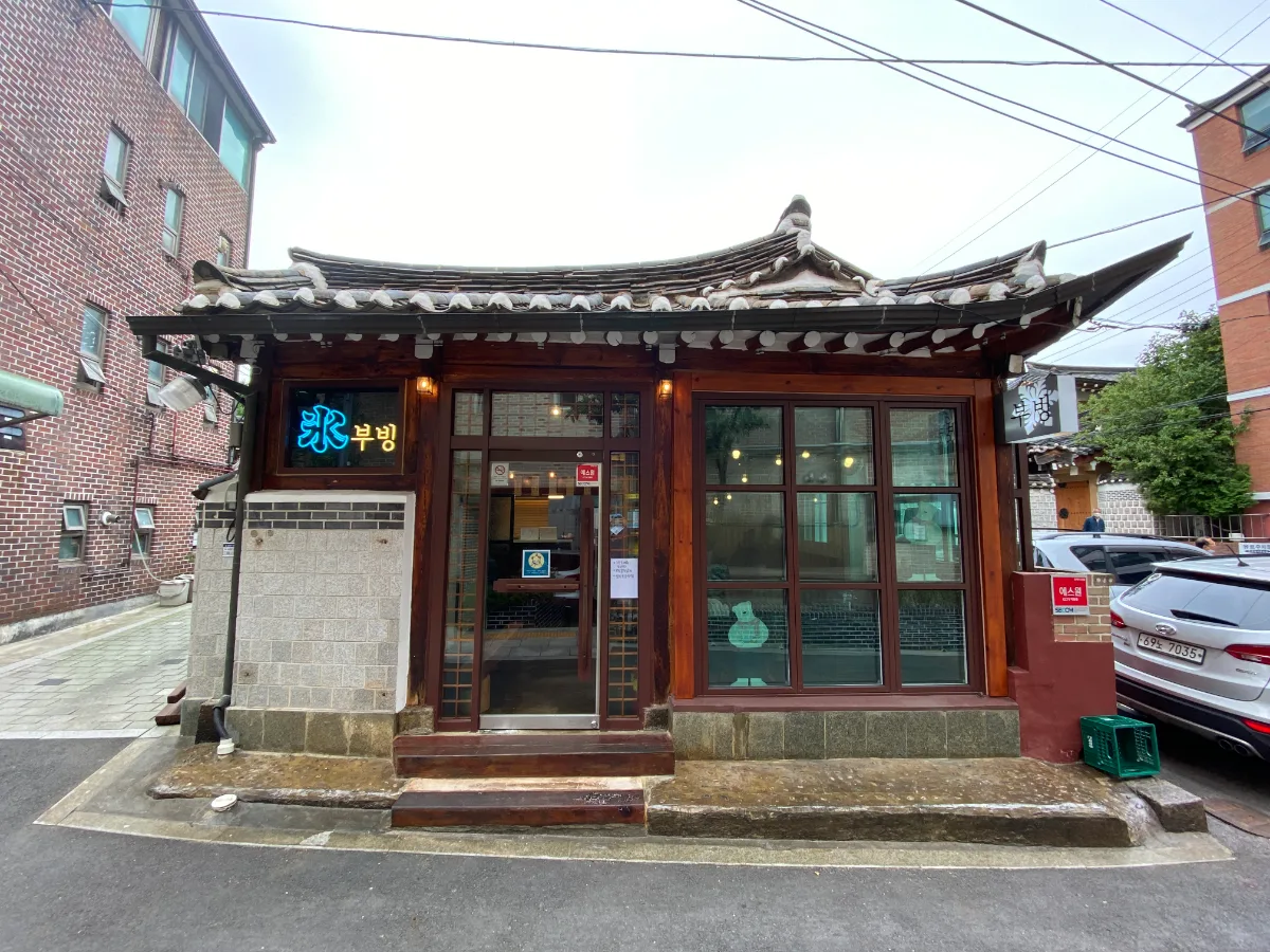 瓦屋根の韓屋とネオン看板の外観