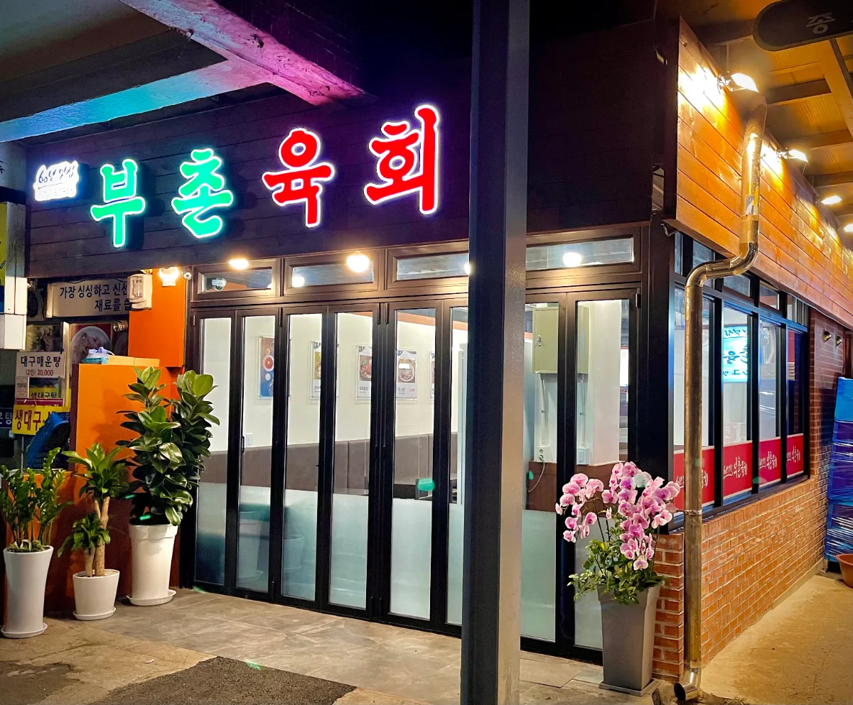 プチョンユッケ 本店 — ネオン看板が光る店先