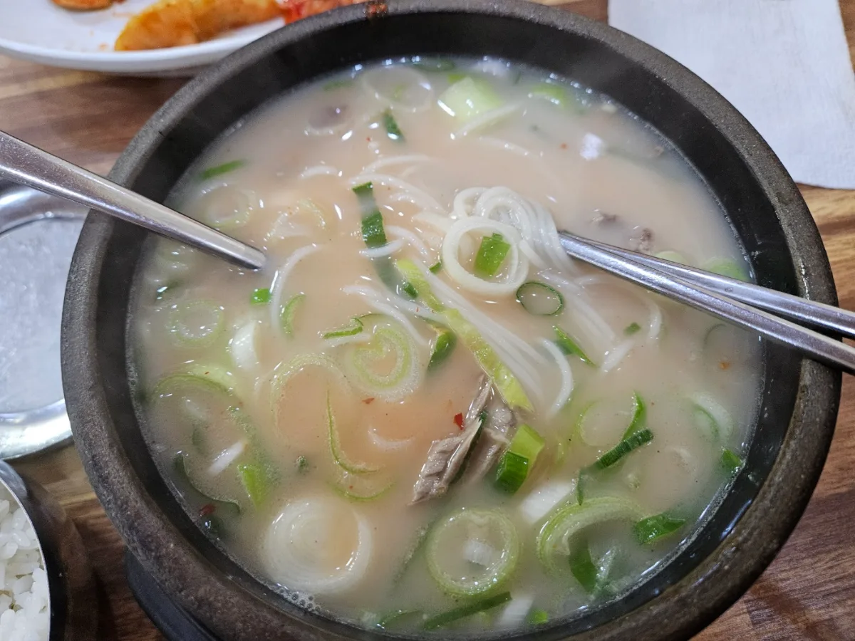 素麺とねぎが入った白いスープ