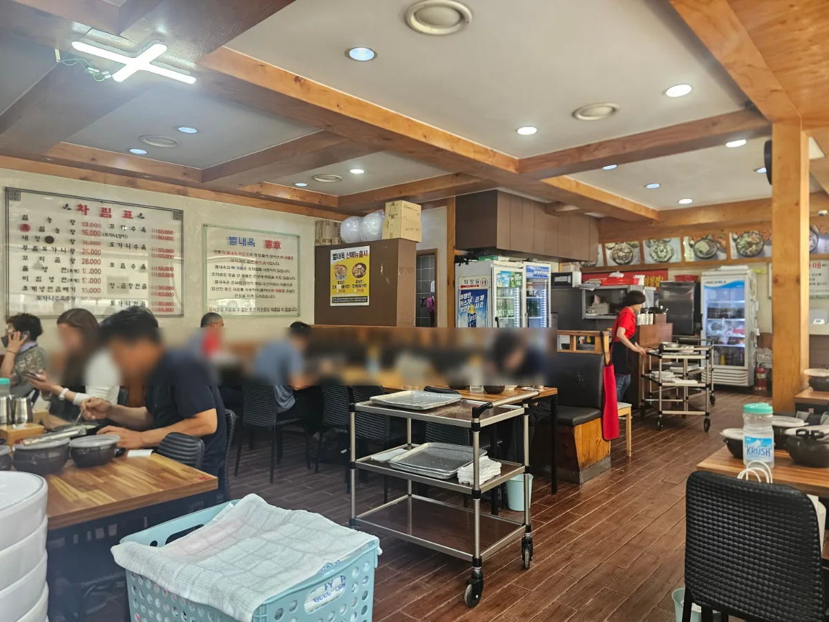 別内屋ソルロンタン — 木の梁が見える店内の客席