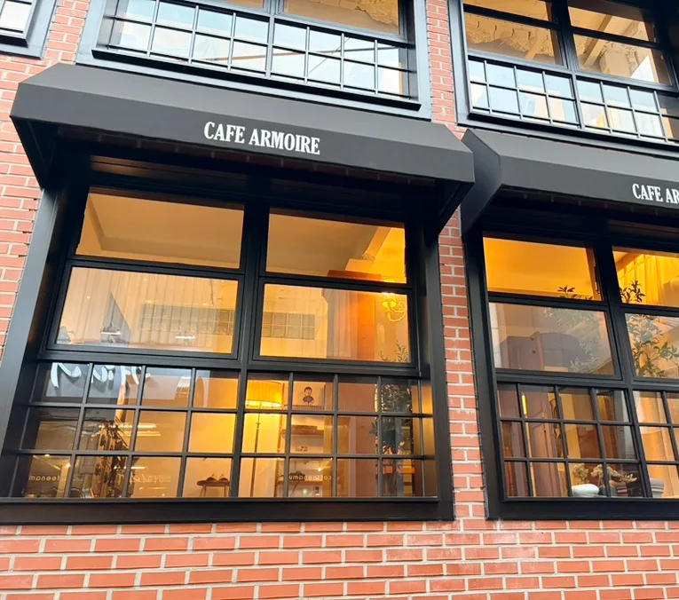 Cafe Armoire 建大店 — 黒いひさしとレンガ壁の店先