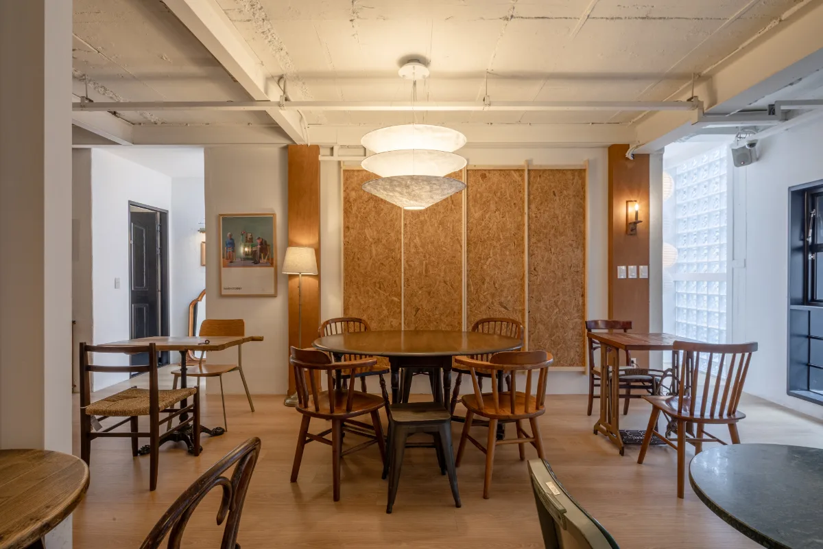 Cafe Armoire 建大店 — 木のテーブルと椅子が並ぶ客席