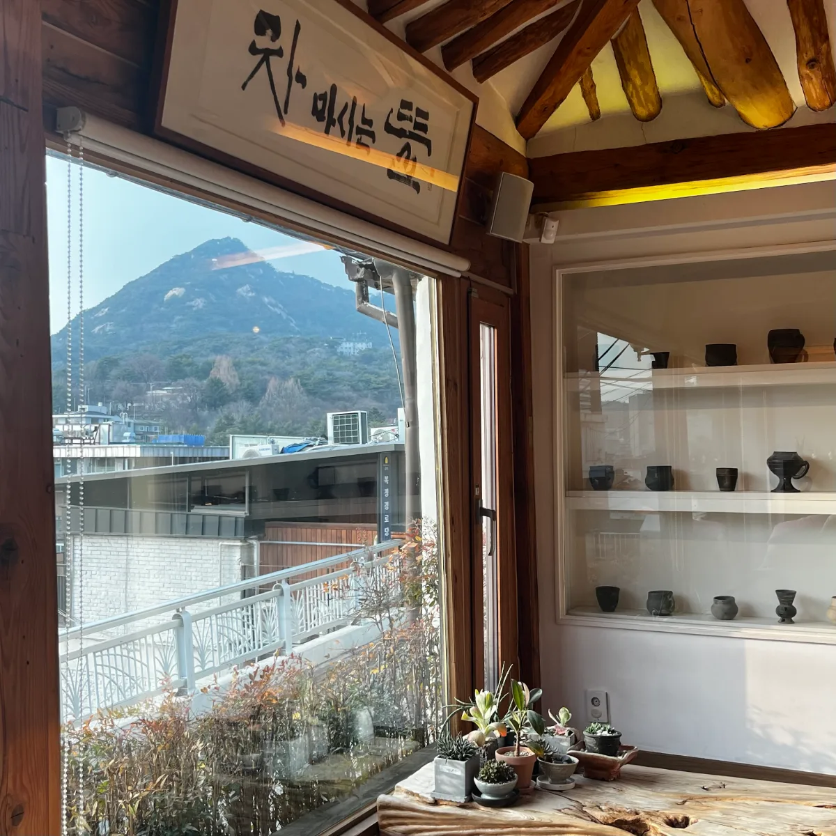 窓越しの岩山と陶器棚