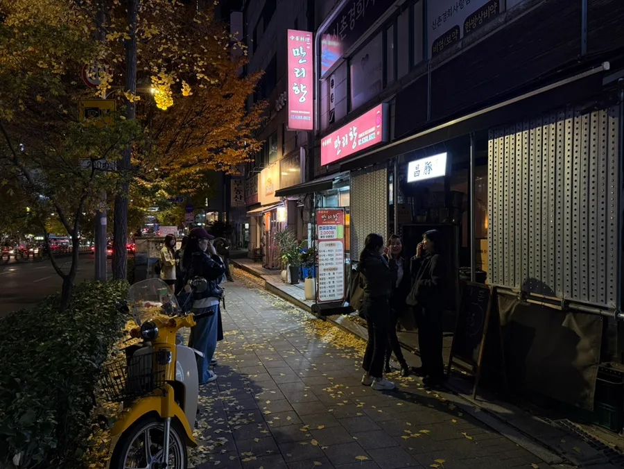 夜の店先に並ぶ人々