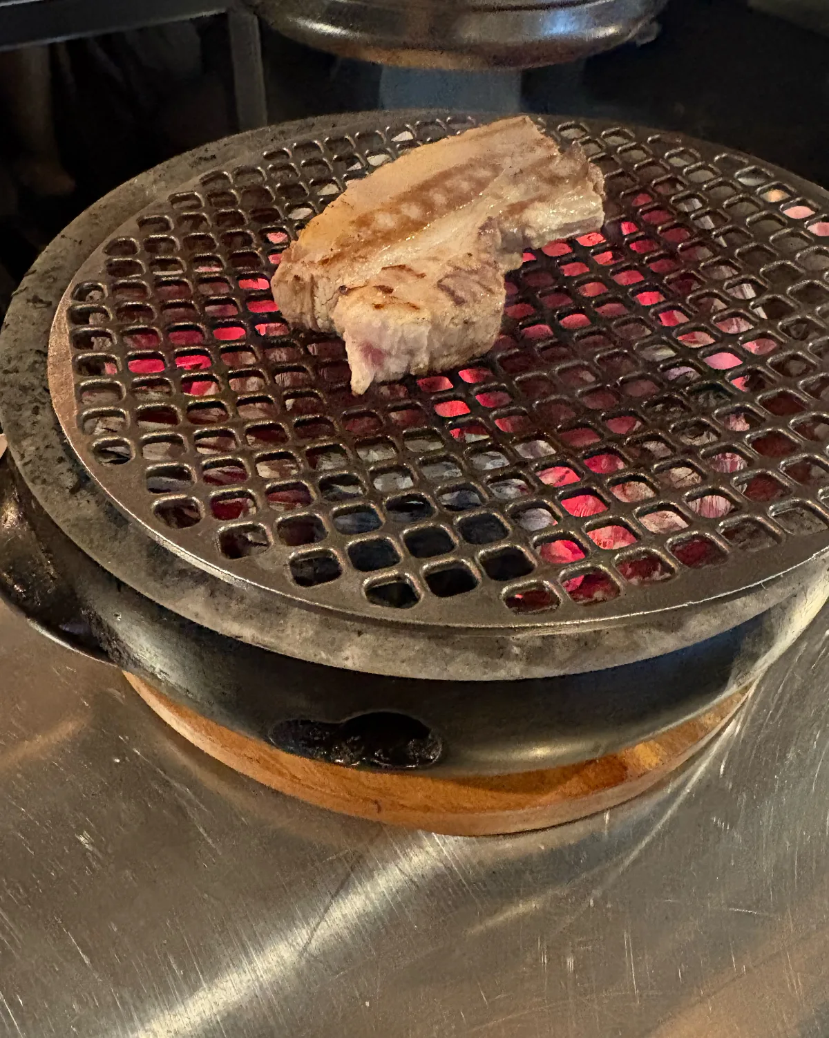 炭火の網で焼く厚切り豚肉