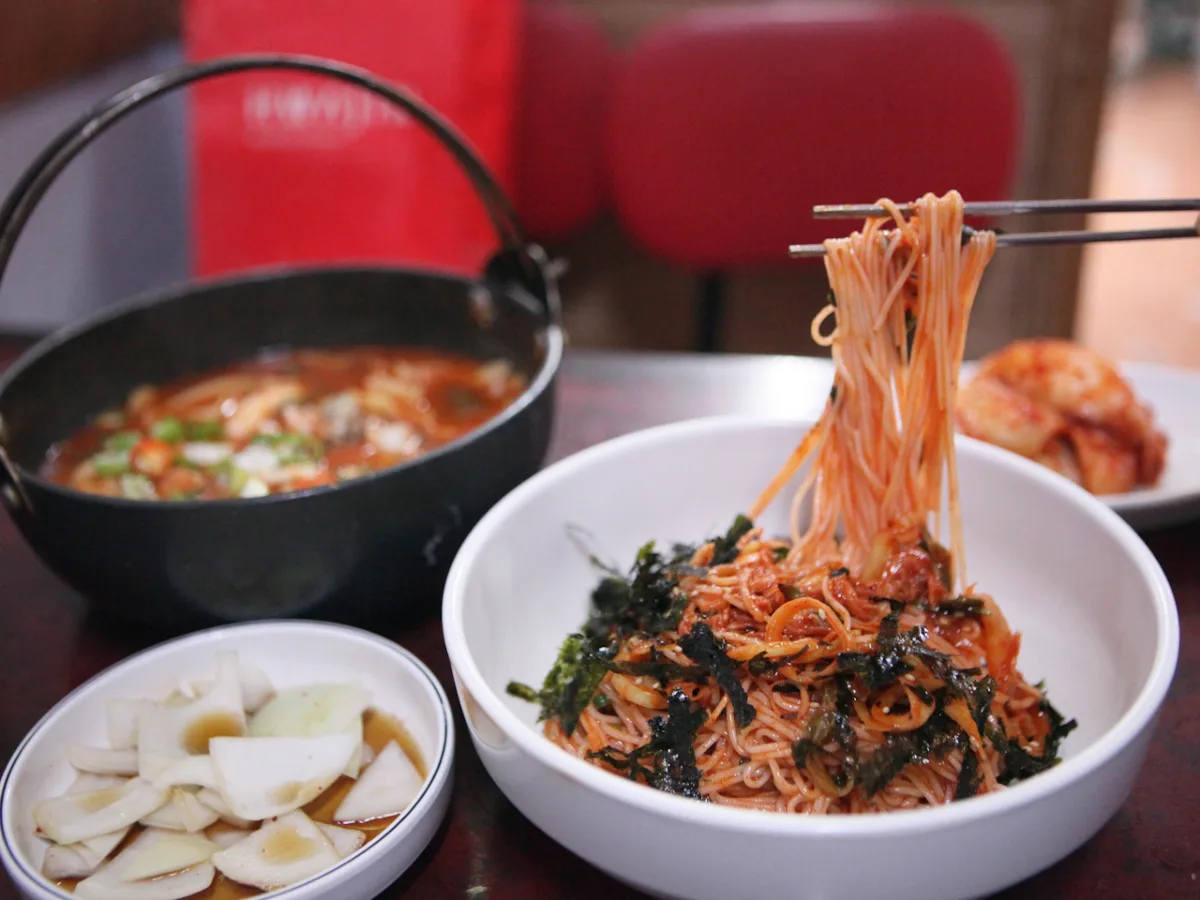 体府洞チャンチチッ 本店 — 箸で持ち上げた赤い和え麺
