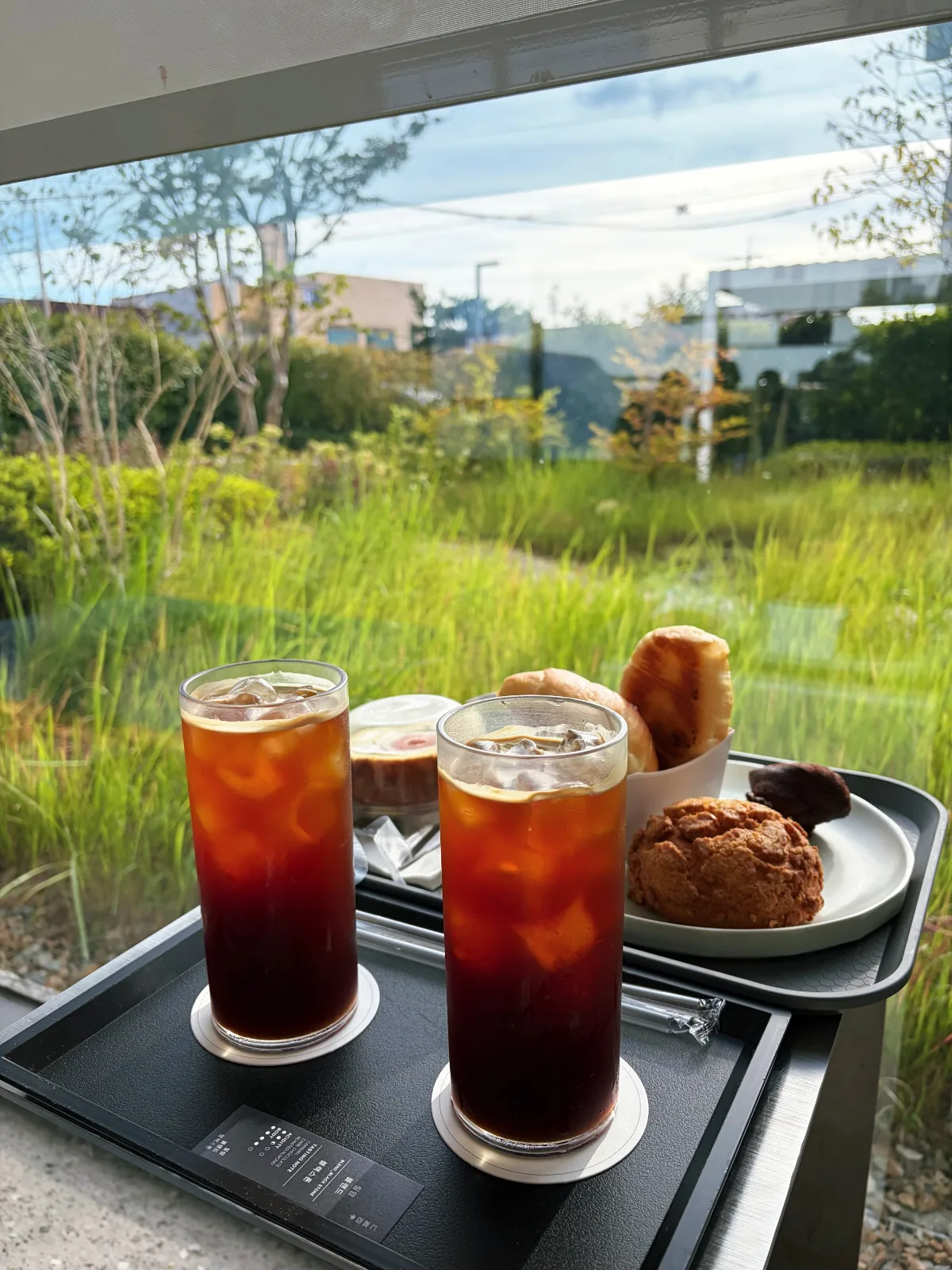 七岩四季 — 芝生の見える窓辺のアイスコーヒーとパン