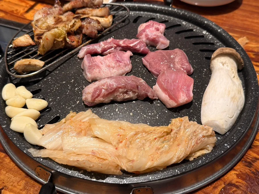 鉄板に並んだ豚の希少部位とキムチ