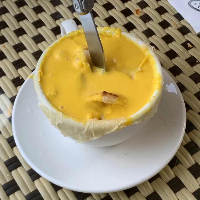 Corned e pepe — パンの器に入った黄色いスープ