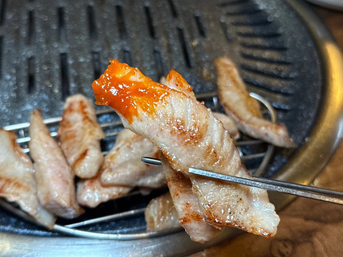 テフン精肉食堂 — たれをのせた焼き豚肉