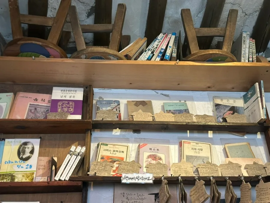 手書き札が並ぶ古書棚