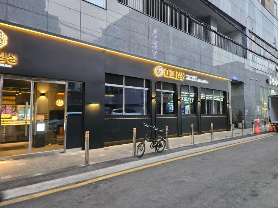 デペ・カムソン 蚕室本店 — 黒い壁と看板が並ぶ店先