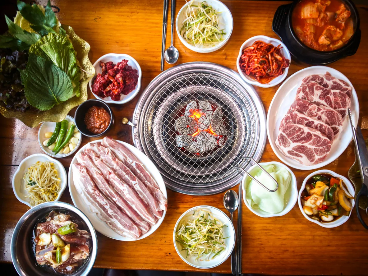 大成カルビ — 炭火網を囲む肉と副菜