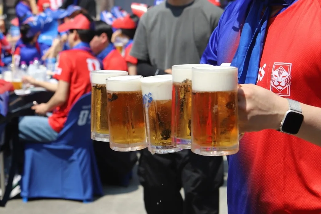タルマジ・クァンジャン・バーベキュー 本店 — 生ビールジョッキを運ぶ手元