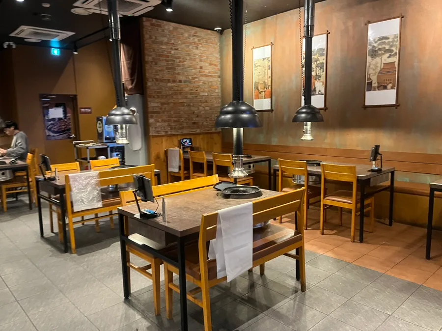 ダンマク 石村湖店 — 排煙フードの並ぶテーブル席